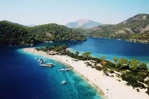 aerial photography of yachts on blue sea viewing mountain under blue and white skies during daytime